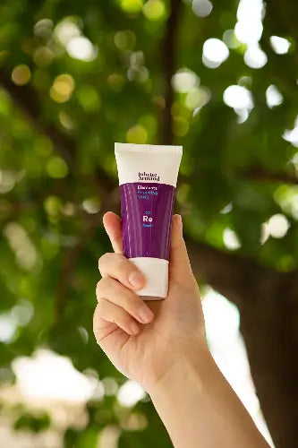Juliette Armand Repairing Mask 50 ml in de hand tegen een natuurlijke achtergrond, herstellend masker voor kalmering en herstel van de huid. Puur Diana Shop Nuenen