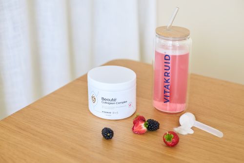 Pot Beauté Collageen Complex met roze drank in Vitakruid fles en rood fruit op tafel