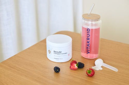 Pot Beauté Collageen Complex met roze drank in Vitakruid fles en rood fruit op tafel