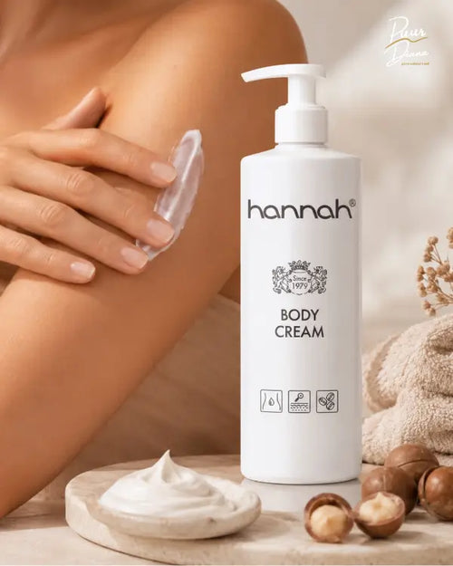 hannah Body Cream 500 ml in warme spa setting met zachte huid, crème textuur, handdoeken en macadamia voor intensieve verzorging van de lichaamshuid
