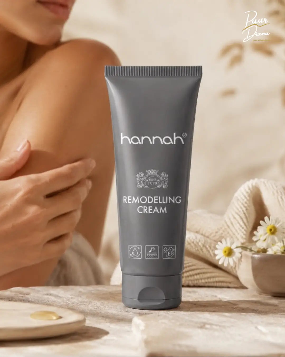 hannah Remodelling Cream 65 ml in warme spa setting met zachte huid, kamillebloemen en zandkleurige doeken voor intensieve verzorging van littekens, fijne lijntjes en droge huid
