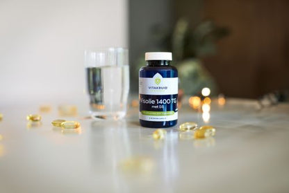 Vitakruid Visolie 1400 TG met D3 30 softgels, lifestylefoto met een glas water bij het innemen van het supplement. Puur Diana Shop Nuenen